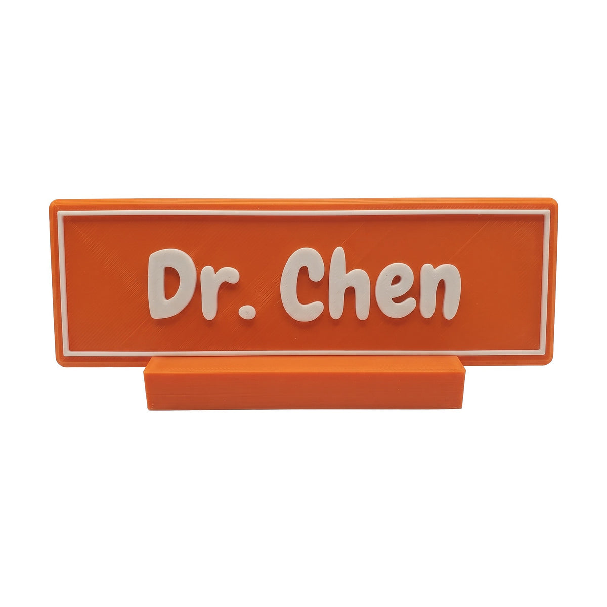 Example personalisation: Small orange desk name plate and foot with white raised lettering and border reading Dr. Chen