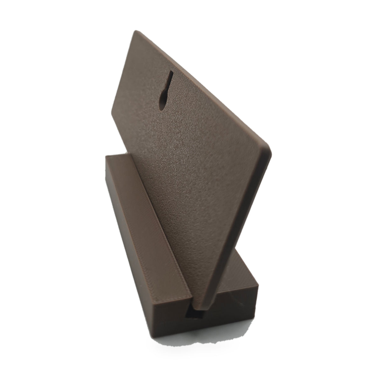 Back of the brown desk name plate standing in its brown foot, showing the keyhole slot for hanging it on a wall