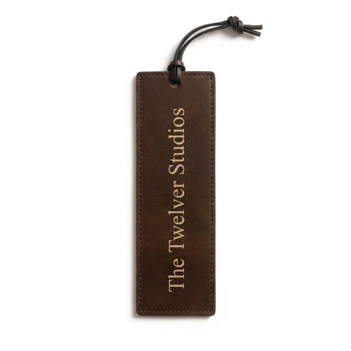 Brown PU leather bookmark with cord tie, engraved in gold with The Twelver Studios, on white